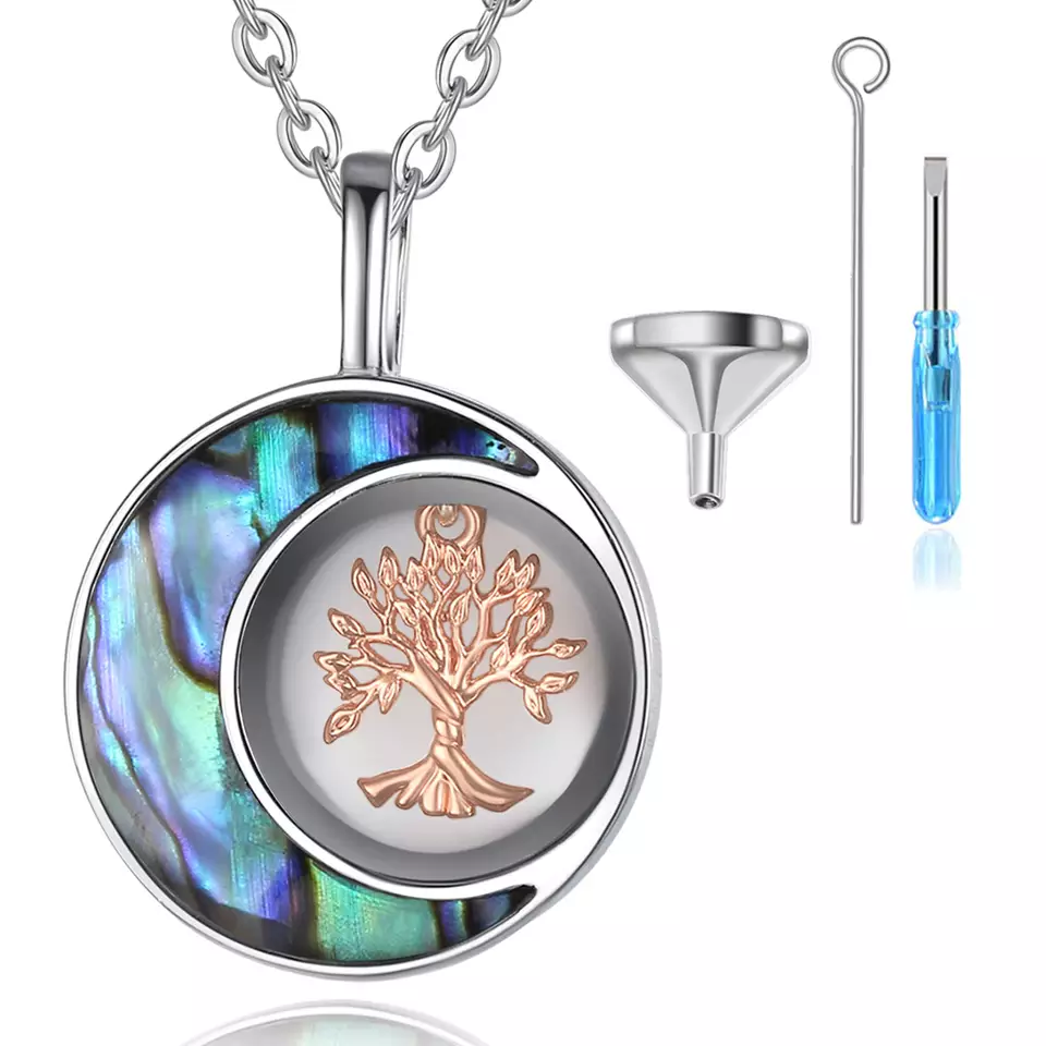 Zoomed in Image of the cremation necklace with a white background. Next to it is a screw along with a funnel kit meant for inserting ashes inside the pendant.