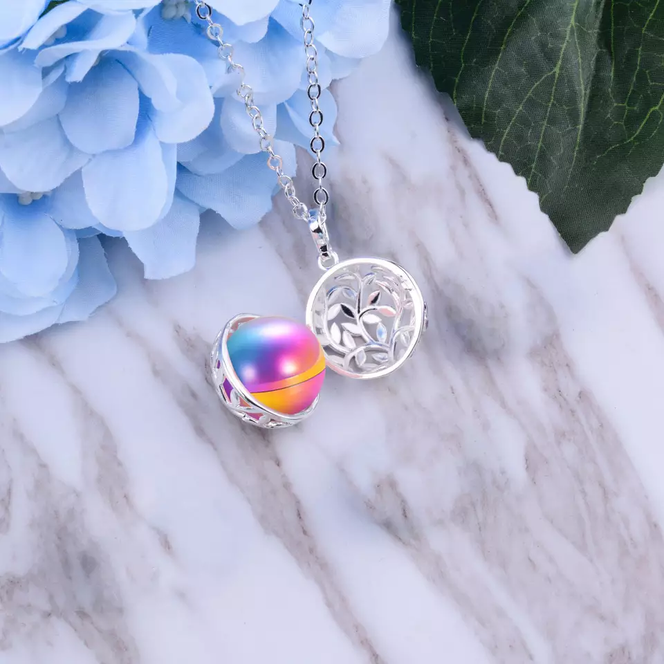 Image of an opened cremation bola pendant with a rainbow ball.